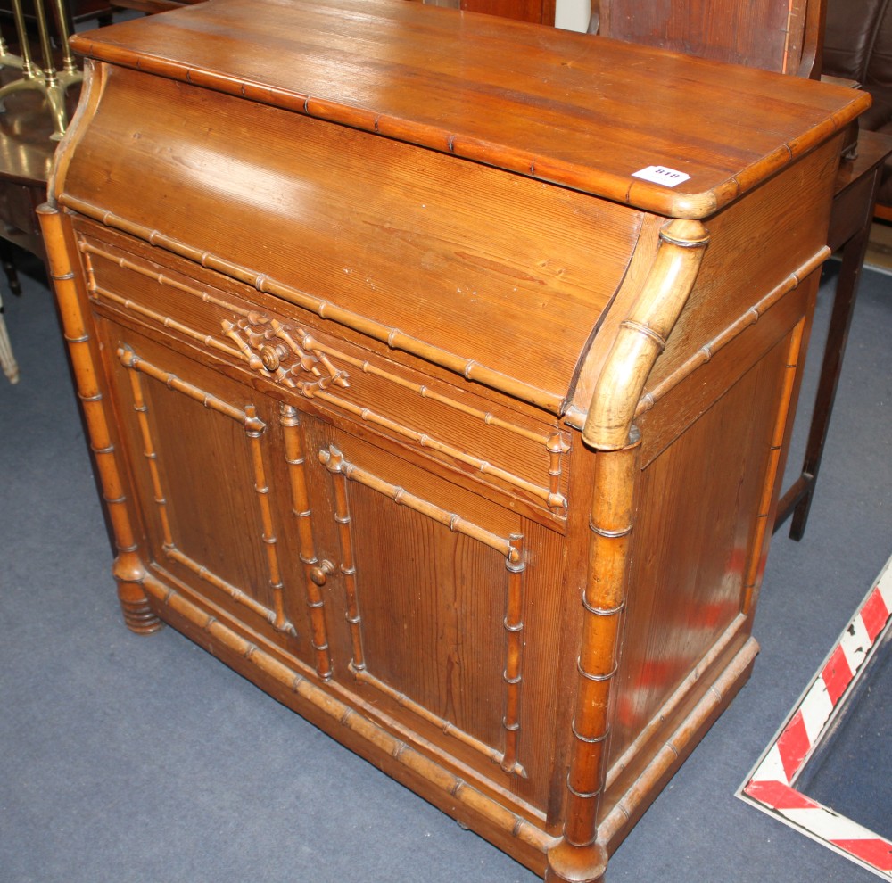 An Edwardian pine washstand, the rising top opening to reveal marble lined interior and mirror, over a drawer and bamboo moulded cupboa